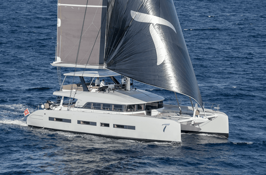 Luxury sailing catamaran with modern design and large sails navigating the open ocean, showcasing advanced nautical engineering and high-end yachting features.