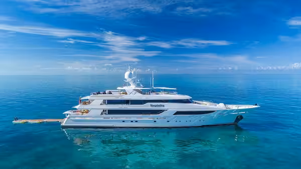 Luxury yacht in clear blue ocean under bright sky showcasing elegant design and serene marine environment.