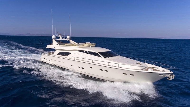 Luxury yacht cruising on open sea under clear blue sky showcasing elegant design and powerful performance.