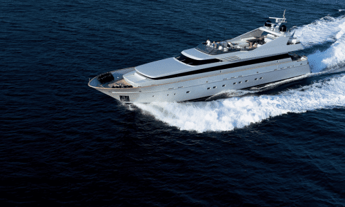 Luxury yacht cruising on the open sea with passengers enjoying the sun on deck.