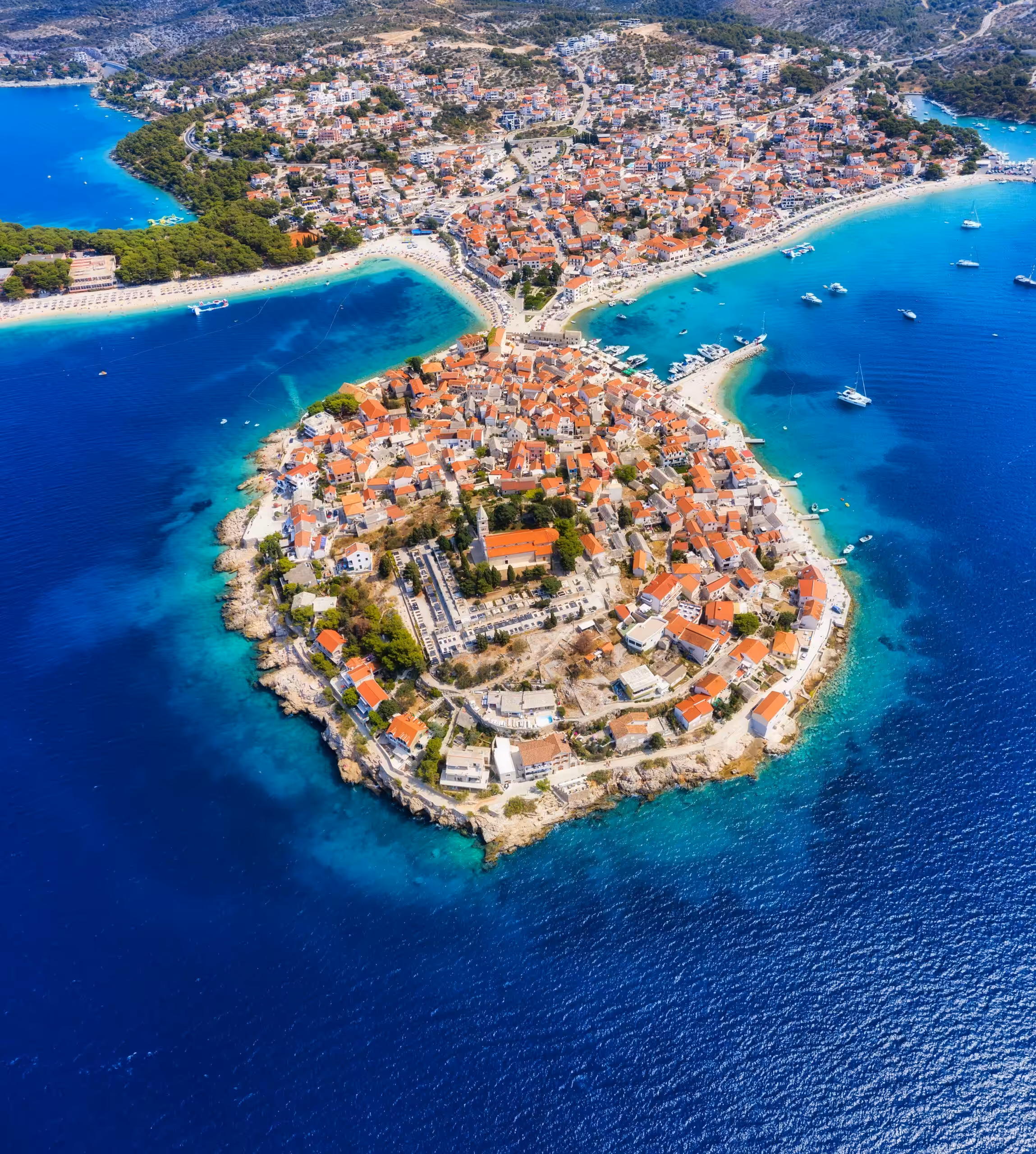 Primosten town, Croatia. View of the city from the air. Seascape with beach and old town. View from drone on the peninsula with houses. Landscape during sunset. Travel image